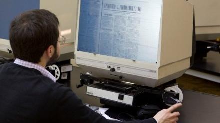 Alumno en práctica revisando microfilm.