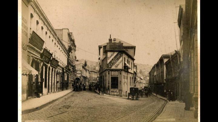 Calles céntricas de Valparaíso, con un aviso publicitario de Fotografías Leblanc. Cruz de Reyes, [Valparaíso: s.n., ca. 1890].  Monocromo, albúmina sobre papel fibra; 26,5 X 20,5 cm. Año: 1890. Sala Medina. Biblioteca Nacional de Chile.